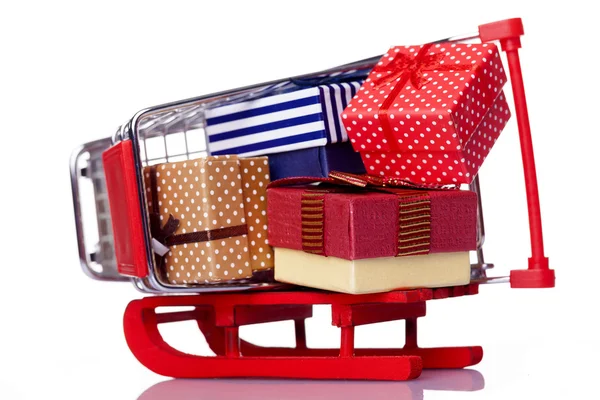 Red sled and shopping cart with gift boxes — Stock Photo, Image