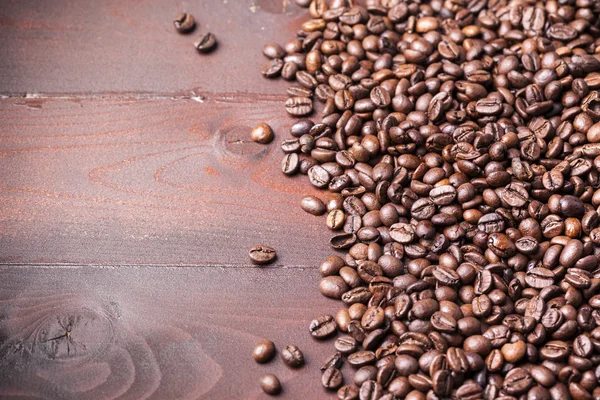 Coffee beans on aged wooden table — Stock Photo, Image