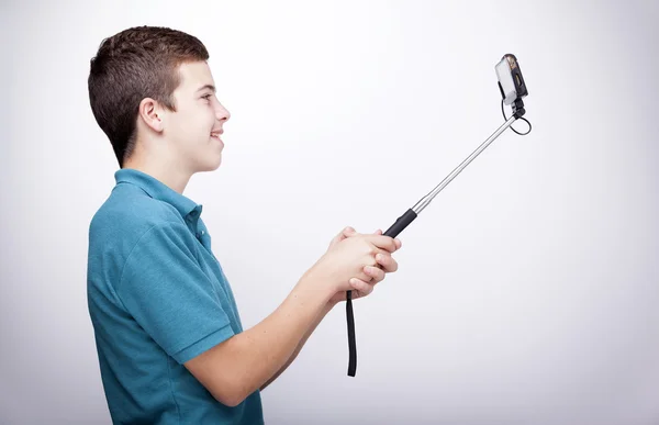 Teen boy using a selfie stick — Stock Photo, Image