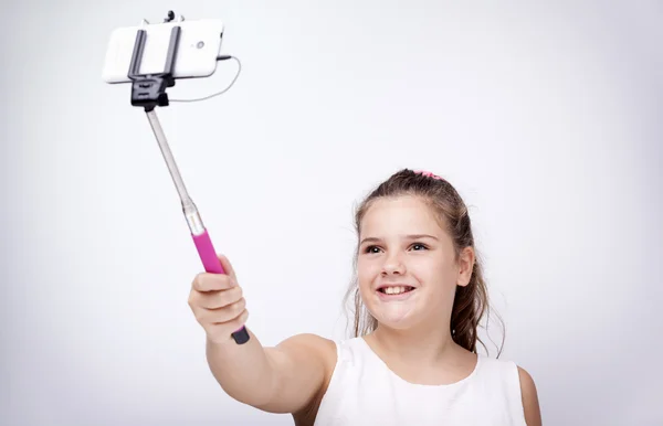 Liten flicka med en selfie pinne — Stockfoto