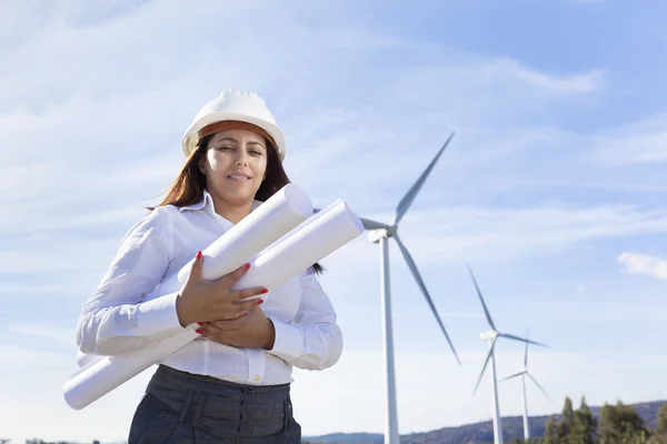 Engineer holding blueprints at wind farm — Stock Photo, Image