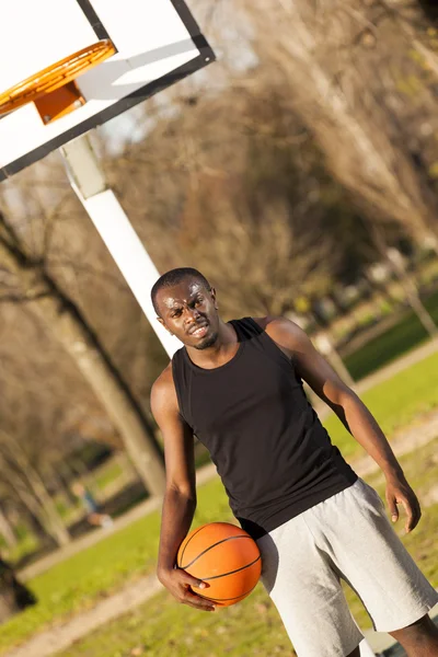 Afroamericano hombre calle canasta jugador sosteniendo un baloncesto — Foto de Stock