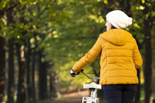 Kvinnan promenader med en vintage cykel på parken — Stockfoto