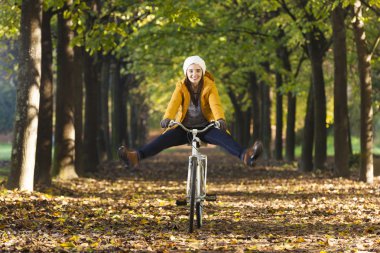 Mutlu gülümseyen kız parkta bir bisiklet sürme