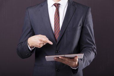 Dijital tablet için işaret eden işadamı