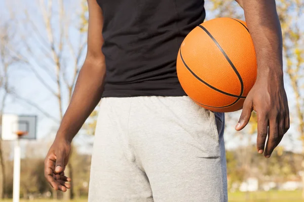 Jogador cesta de rua de pé com uma bola de basquete — Fotografia de Stock