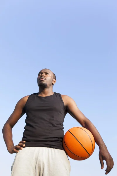 Afroamericano hombre calle canasta jugador sosteniendo un baloncesto — Foto de Stock