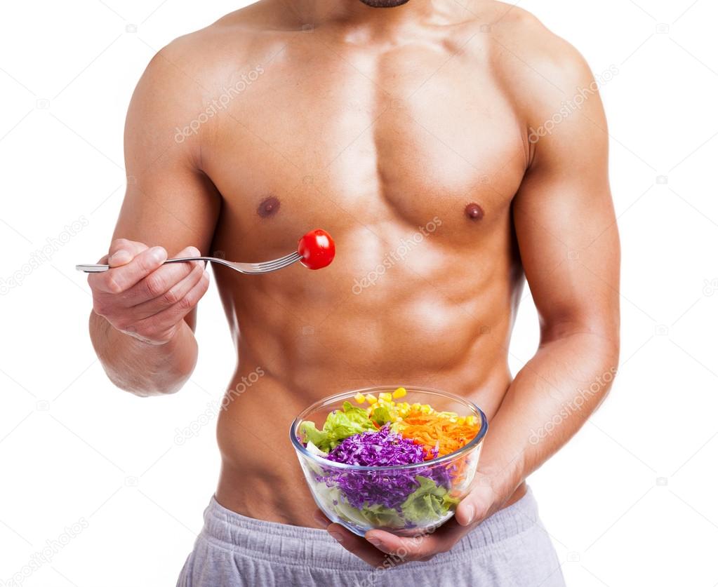 Fit man holding a bowl of fresh salad