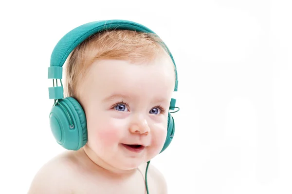 Bebê sorridente com fones de ouvido ouvindo música — Fotografia de Stock