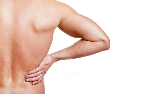 Muscular young man holding his back in pain — Stock Photo, Image