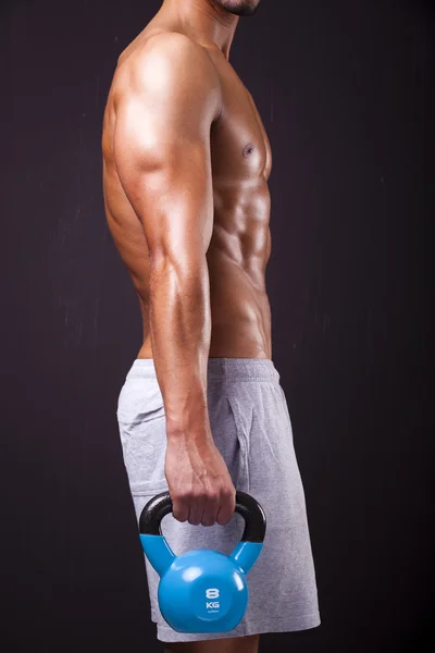 Young fitness man holding a dumbbell — Stock Photo, Image