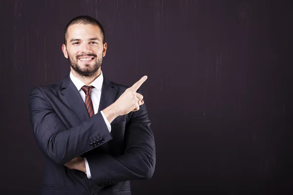 Uomo d'affari sorridente che punta — Foto Stock