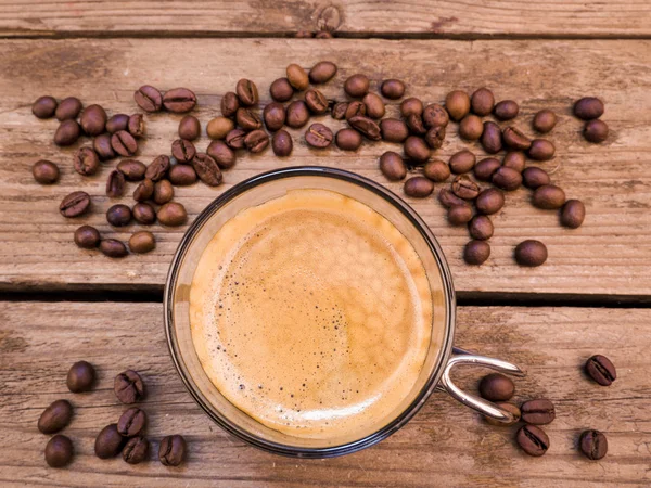 Cup of coffee on aged wooden table — Stock Photo, Image