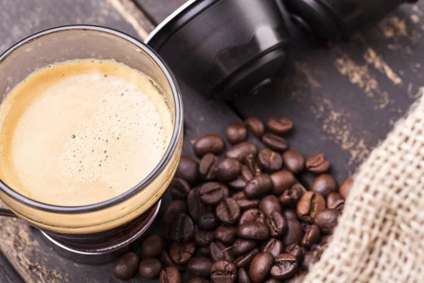 Tazza di caffè e capsule su un tavolo di legno — Foto Stock