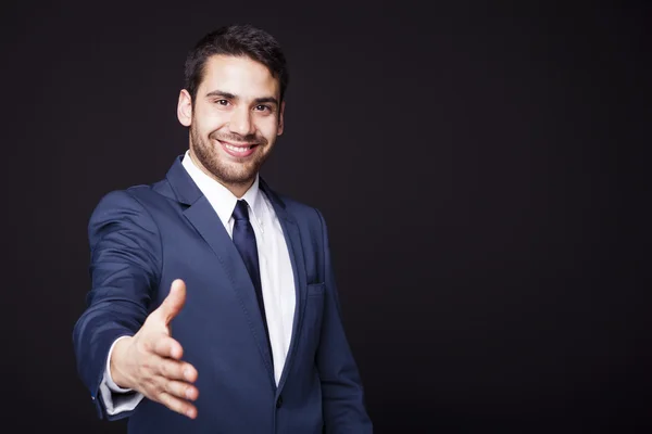 Empresário dando a mão por aperto de mão — Fotografia de Stock