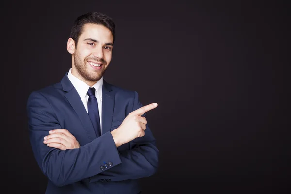 Hombre de negocios guapo apuntando al copyspace — Foto de Stock