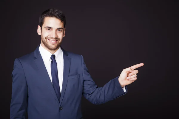 Handsome businessman pointing at copyspace — Stock Photo, Image