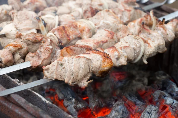Kebabs on skewers cooked on the coals in the smoke — Stock Photo, Image