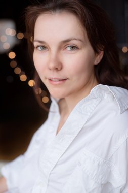 Yatağın üstüne oturan adamın gömleği güzel genç kadın