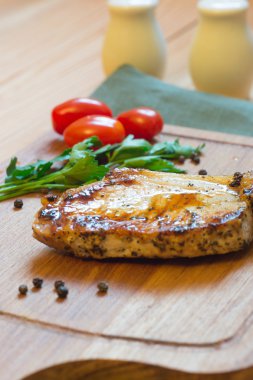 Domuz pirzolası (boyun kesim) kesme tahtası üzerinde sulu ızgara.