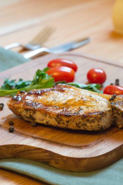 Domuz pirzolası (boyun kesim) kesme tahtası üzerinde sulu ızgara.