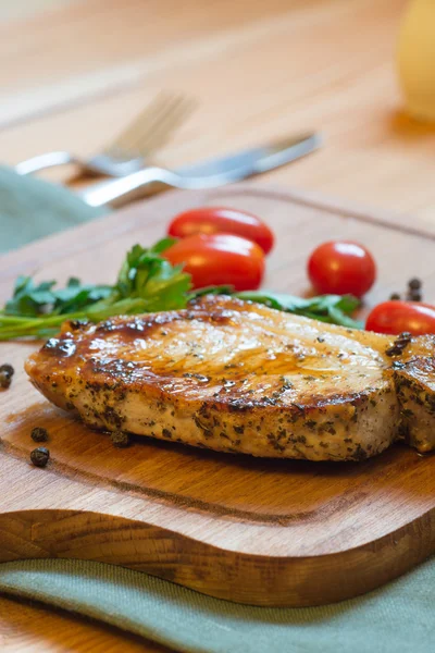 Juicy grilled pork chop (neck cut) on cutting board. — Stock Photo, Image