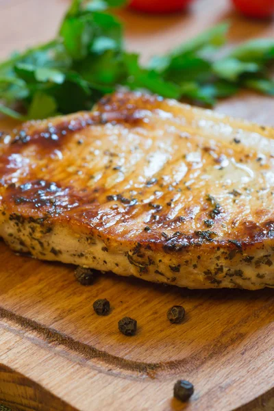 Domuz pirzolası (boyun kesim) kesme tahtası üzerinde sulu ızgara.