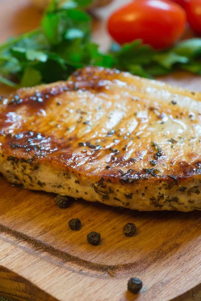 Domuz pirzolası (boyun kesim) kesme tahtası üzerinde sulu ızgara.