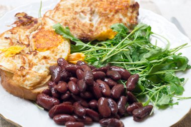 Omlet beyaz tabakta yedeklenmiş fasulye ile