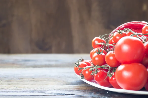 Colorful tomatoes on wooden table background. Side view — Stock Photo, Image