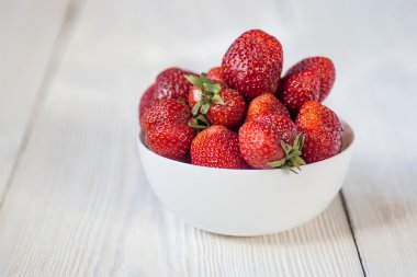 İştah açıcı çilek kabın içinde. Beyaz rustik masa