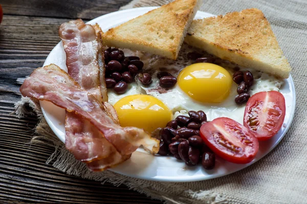 Café da manhã inglês com bacon, ovo frito, feijão assado — Fotografia de Stock