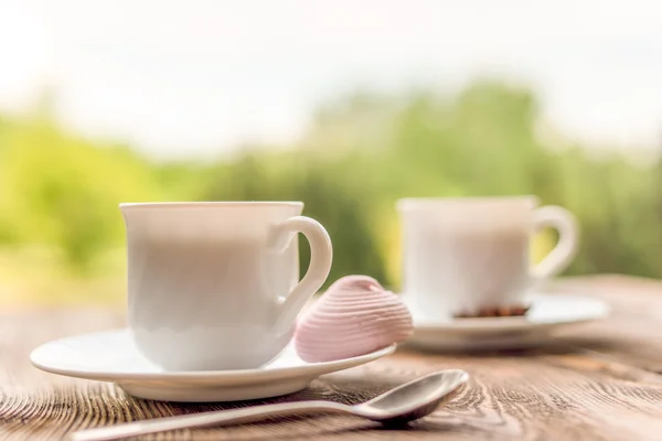 Duas xícaras de chá e marshmallow na mesa de madeira rústica — Fotografia de Stock