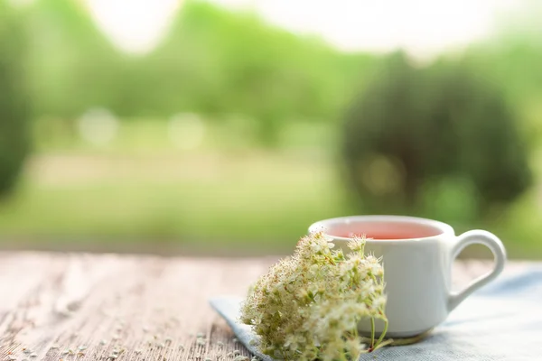 Taza de té en la mesa con hierbas —  Fotos de Stock