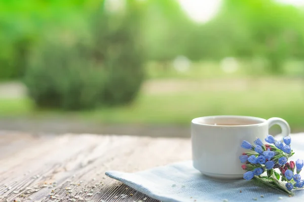 Até com chá de tília e flores em mesa de madeira no jardim — Fotografia de Stock