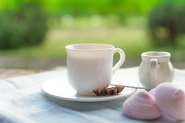 Hasta con té de tilo y flores en la mesa de madera en el jardín —  Fotos de Stock