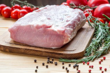 Kesme tahtasında çiğ domuz eti ve sebze.