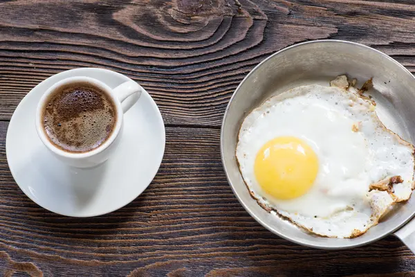 Ovo frito na panela e xícara de café branco para o café da manhã . — Fotografia de Stock