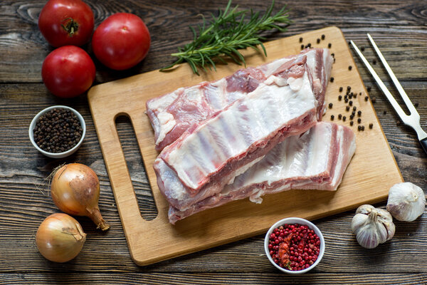 Close up Raw Pork Rib meat on Wooden Board with a Jar of Spices