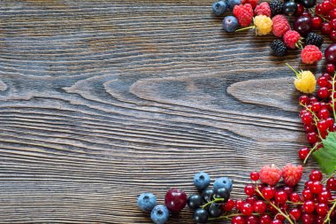 Ahşap arka plan üzerinde meyveleri. Yaz veya bahar organik Berry ove
