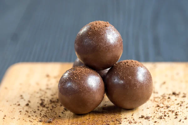 Três bolas de chocolate no fundo de madeira — Fotografia de Stock