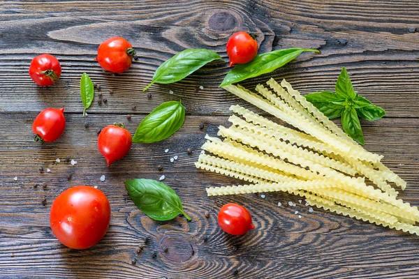 Ingredienti per pasta. Pomodori ciliegini, pasta spaghetti, basilico e s — Foto Stock