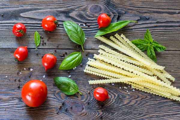 Ingredienti per pasta. Pomodori ciliegini, pasta spaghetti, basilico e s — Foto Stock