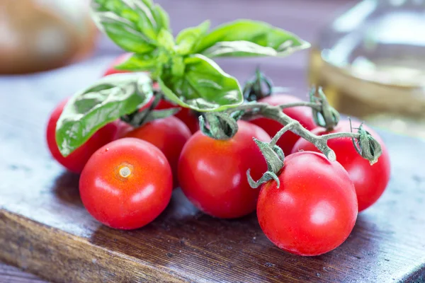 Tomatoes and basil on the wooden background — Stock Photo, Image