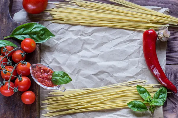 Espaguetis, albahaca, tomates y ajo, comida italiana sobre madera b — Foto de Stock