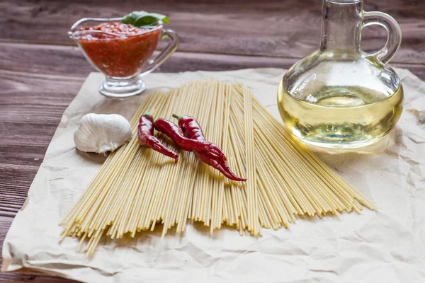 Ingredienti per pasta. pomodoro, aglio, pepe e olio su bac di legno — Foto Stock