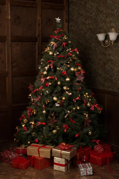 Árbol de Navidad bellamente decorado con muchos regalos debajo de él — Foto de Stock