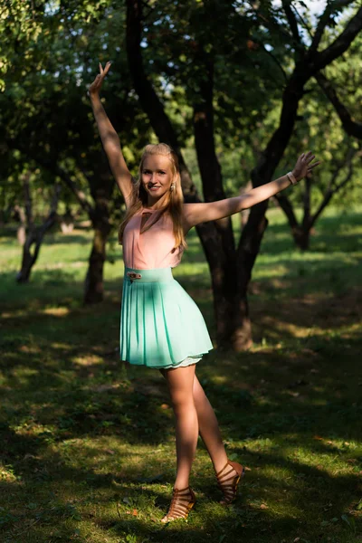Ung flicka sprider händer med glädje i park skuggor — Stockfoto