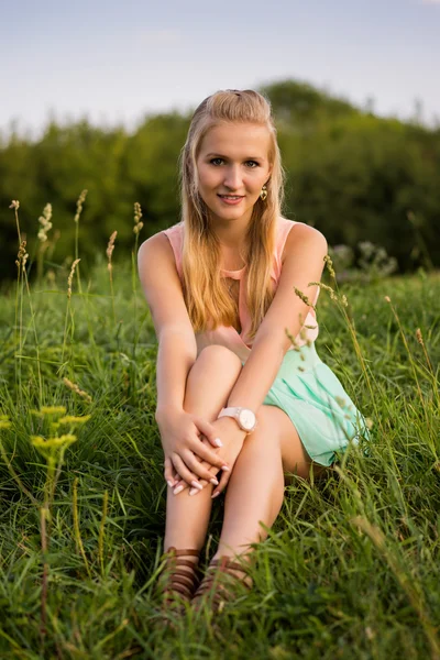 Beautiful girl sitting on a grass,  warm sunny day — Stock Photo, Image