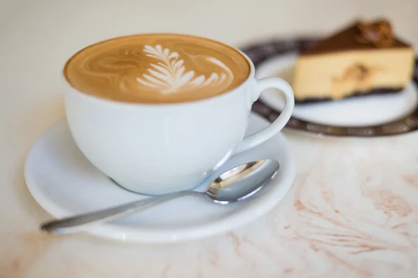 Cappuchino vagy latte kávé a egy sütemény fehér csészében — Stock Fotó